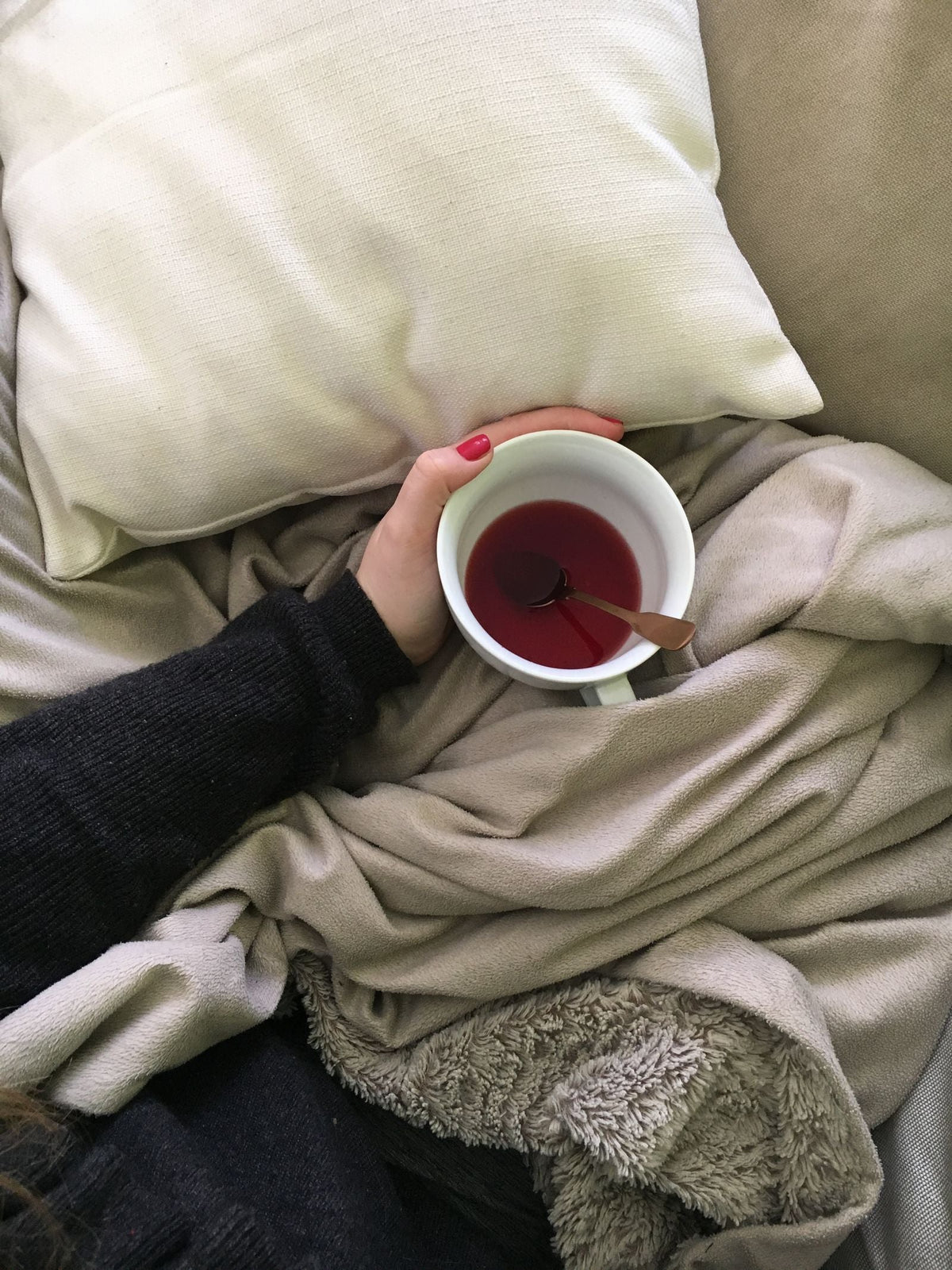 Thé chaud au lit sous une couverture
