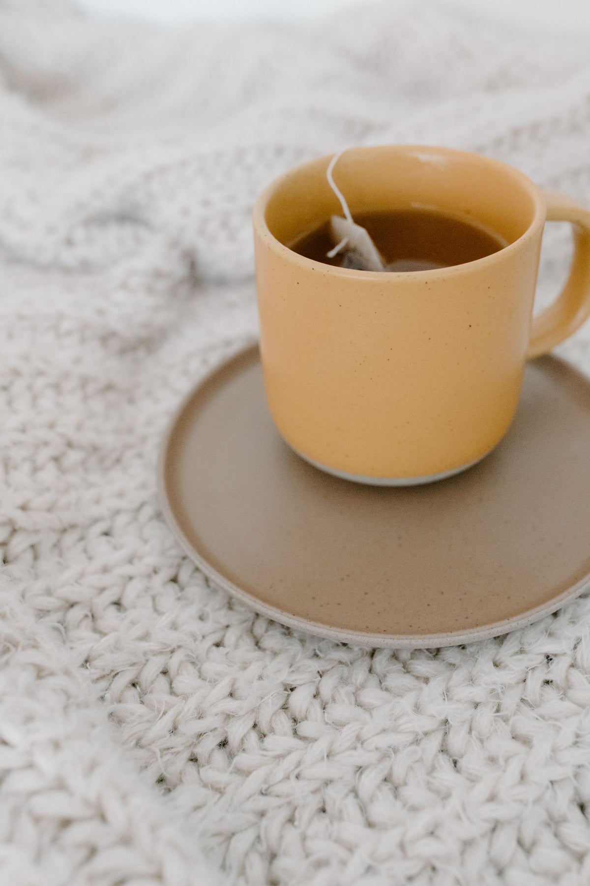Tasse de thé sur un plaid en grosse maille
