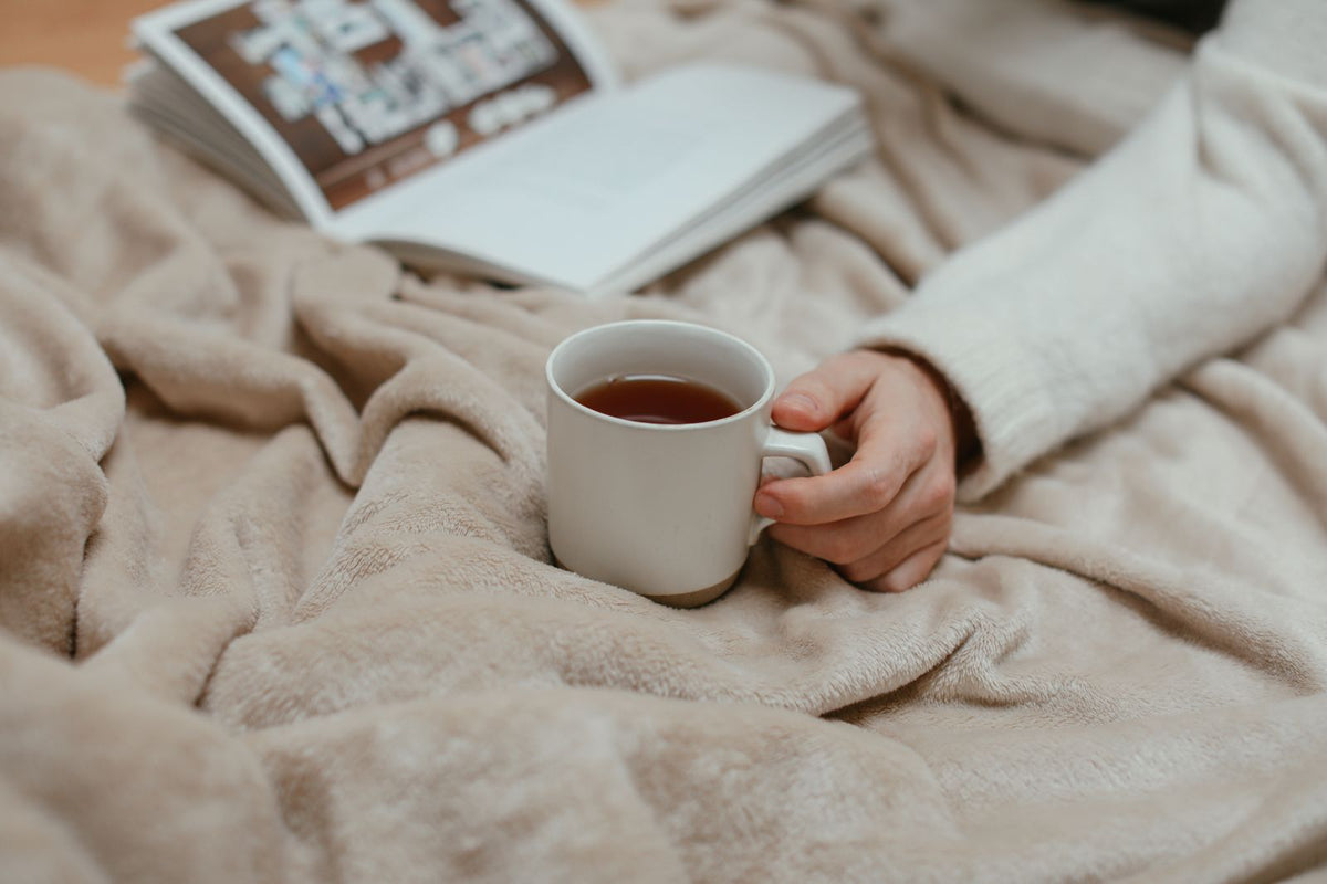 Lecture et thé sous un plaid doux